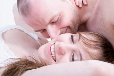 Man kissing woman in bed
